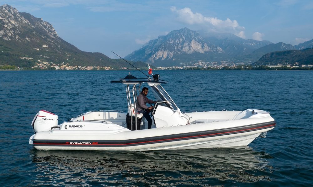 Lungo 8,02 metri e largo 3,08 metri, i colori dominanti di questa versione del Mar.Co R-Evolution 26 sono il bianco ed il rosso, interrotti soltanto da una striscia nero carbon sui due tubolari. Ovviamente questa chase boat può essere personalizzata a piacere anche se, devo ammettere, questa combinazione mi piace molto. Anche il Mercury 450R ci sta benissimo, la colorazione in tinta gli da un tocco di stile decisamente sportivo. A centro barca troviamo uno splendido T-Top: costruito in vetroresina ricorda quello del R-Evolution 35, con due portaoggetti progettati con grande cura ed una plancia dallo stile moderno che si abbina alla seduta a T e dell’elegantissimo poggiapiedi bianco. La qualità della realizzazione di questo gommone, disegnato da Federico Gerna, è altissima e si vede in ogni dettaglio: dai corrimano, alle rifiniture, per arrivare fino alle ampie plancette posteriori che ospitano una pratica scaletta a scomparsa, dotata di manici per rendere la risalita dall'acqua più comoda. Qui tutto è studiato nel minimo dettaglio.